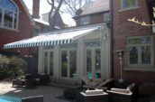 a building with a striped awning overlooking a pool