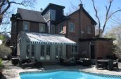 a building with a striped awning overlooking a pool